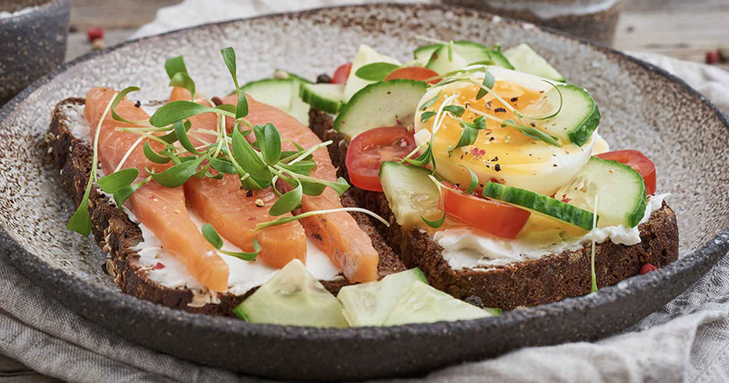 Nordic Health and Diet Traditional Danish sandwich — black rye bread with a salmon, cream cheese, cucumber, tomatoes