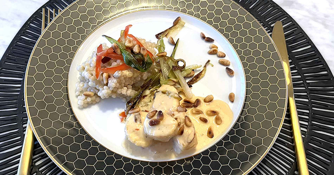 pan fried sea scallops in a garlic and chili cream sauce with pearl couscous and fried green onions