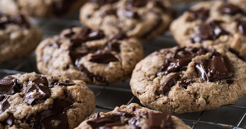Close up of a batch of chocolate chip cookies on wire rack