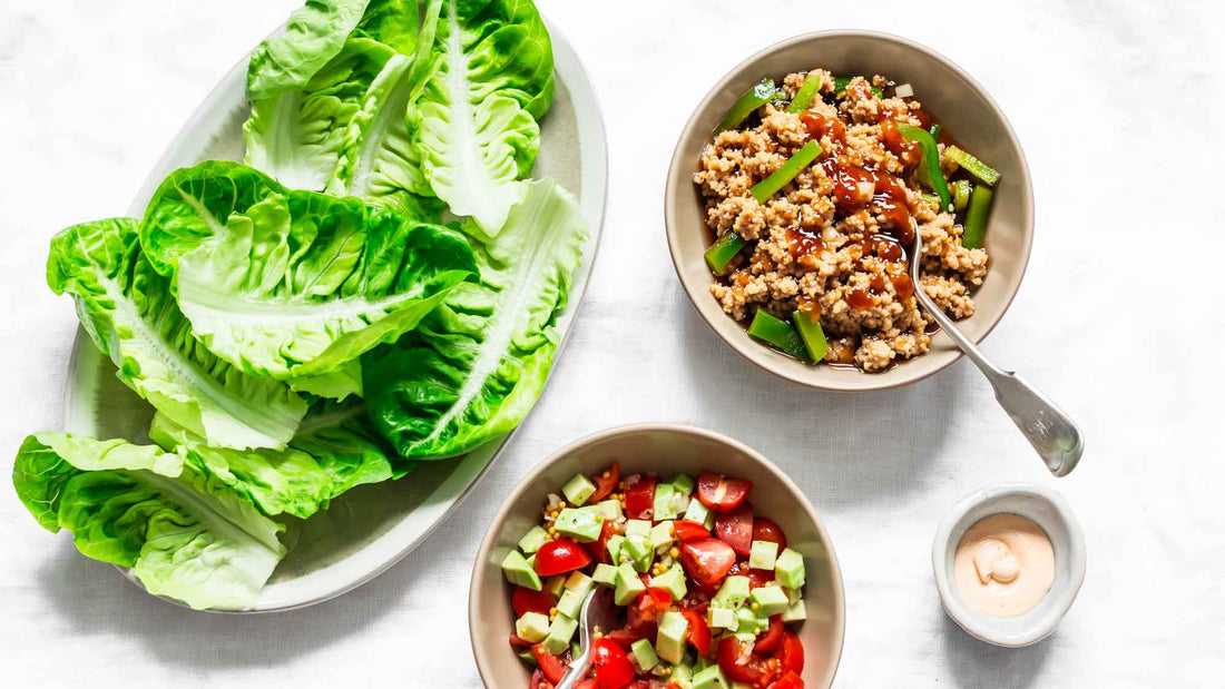 Ingredients for lettuce wrap - romaine, grounded chicken teriyaki, tomato, avocado salad on a light background, top view