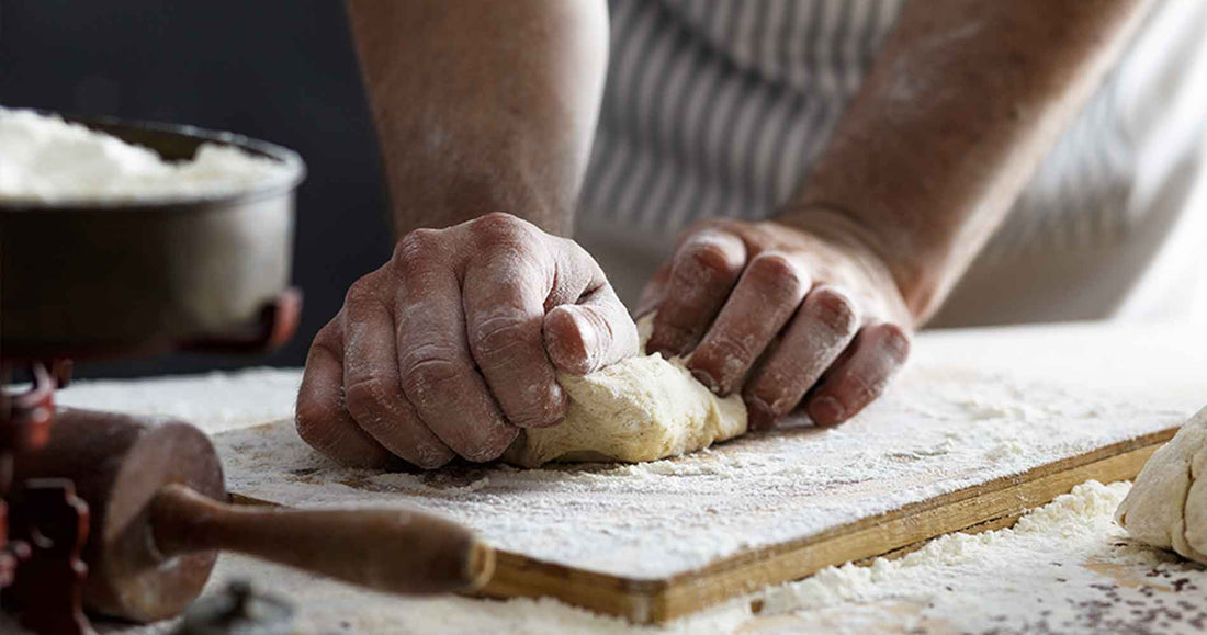 Close up of baker hands kneading dough