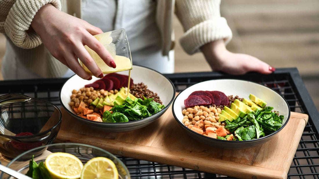 Woman adding homemade dressing to salad bowl