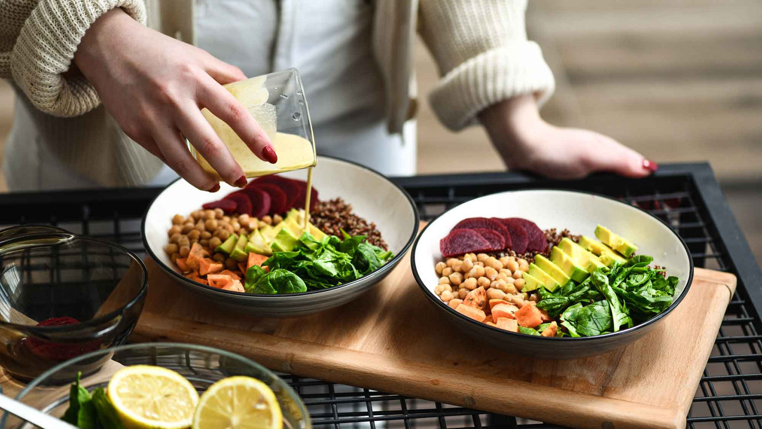 Woman adding homemade dressing to salad bowl