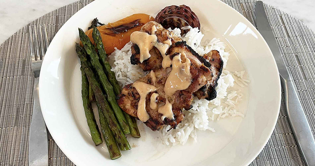 grilled chicken over rice with side of grilled asparagus, onions and yellow peppers
