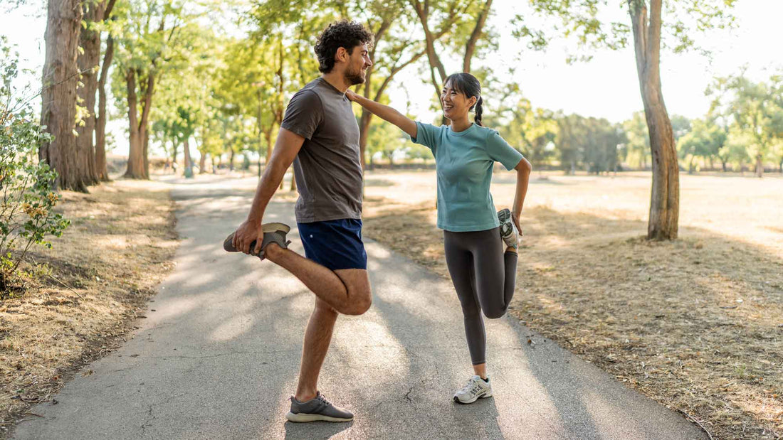2 people stretching together before running in a park 
