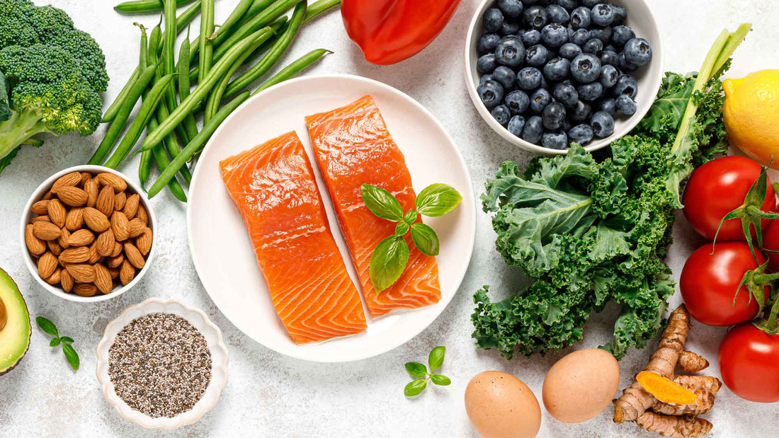 Assortment of nutrient-rich foods including salmon, berries, leafy greens, broccoli, avocado, almonds, chia seeds, lentils, eggs, tomatoes, and other colorful produce.