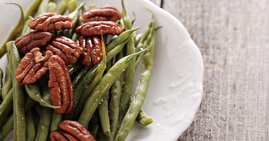 Plate of salted string beans with pecans on top