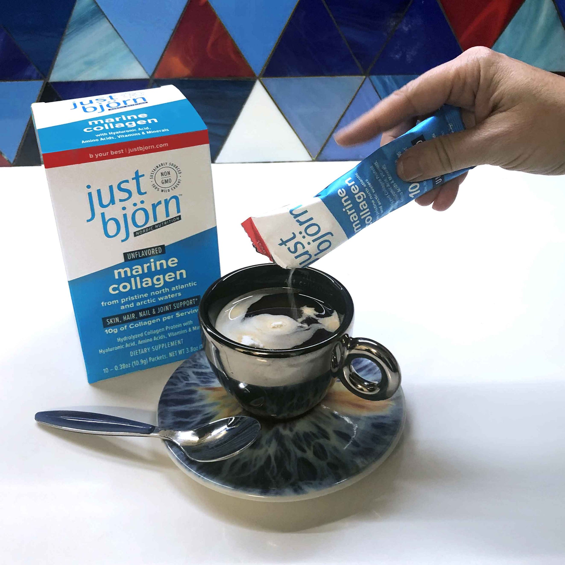person pouring just björn on their coffee (just björn stick pack box in the background)