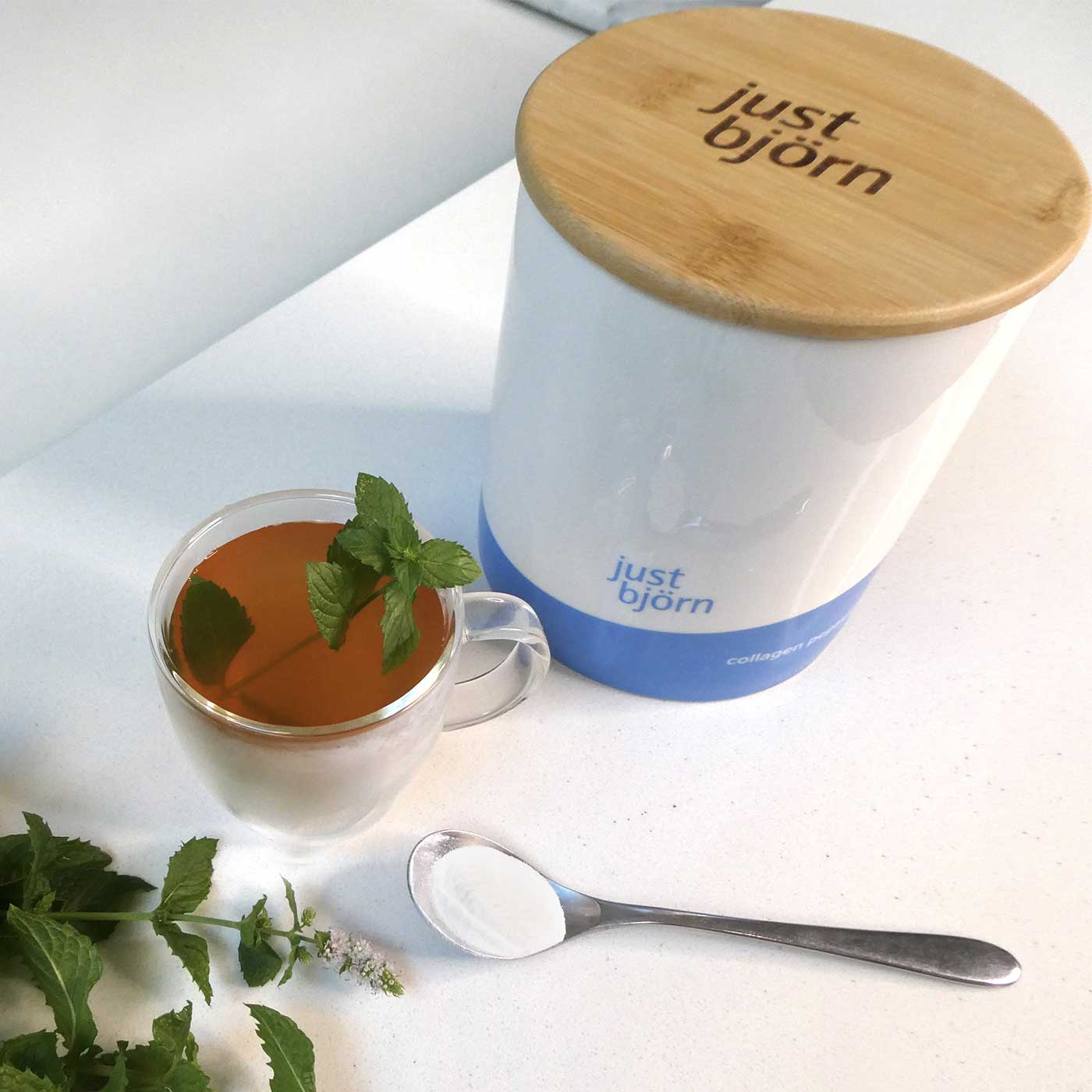 Cup of mint tea with spoonful of just björn marine collagen and ceramic canister
